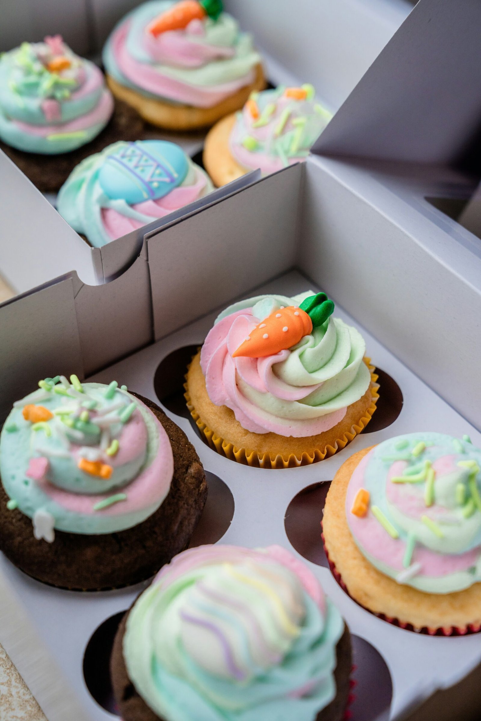 cupcakes with white icing and green and pink icing on top